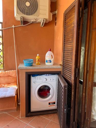 lavadora en una habitación con ventilador en CASA MONELLA mono locale vista mare, en Marinella