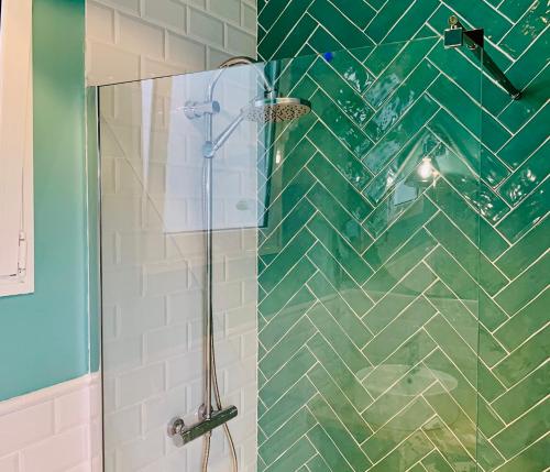 a bathroom with a shower with green and white tiles at Attic Penthouse Downtown Beach 1Gb Fibra in Las Palmas de Gran Canaria