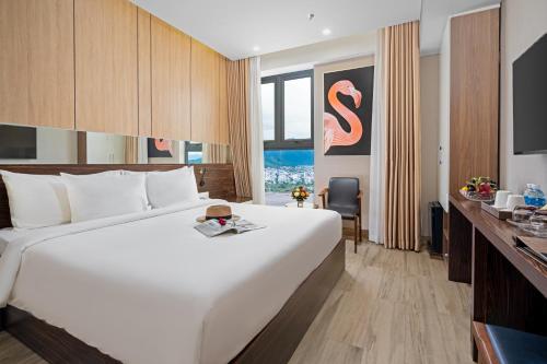 a large white bed in a hotel room at Emerald Bay Hotel & Spa Nha Trang in Nha Trang