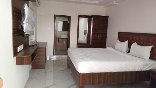 a bedroom with a bed and a television and a bathroom at UNIQUE HOMESTAYS in Kondapur