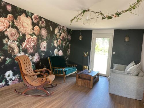 a living room with a flower mural on the wall at Clos du Bois de Gattigny in Maurois