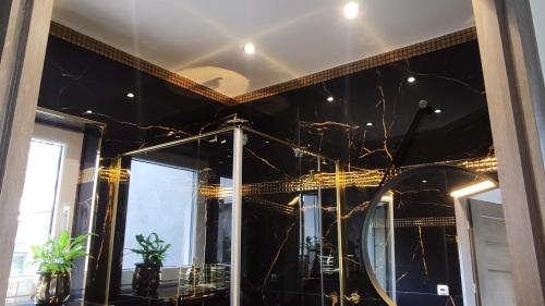 a room with black and gold walls and a mirror at Dobry Dom II in Staszów