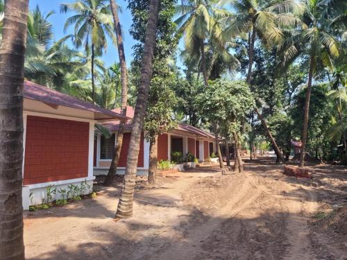 a house with palm trees in front of it at Cocorico Beach Resort in Dapoli