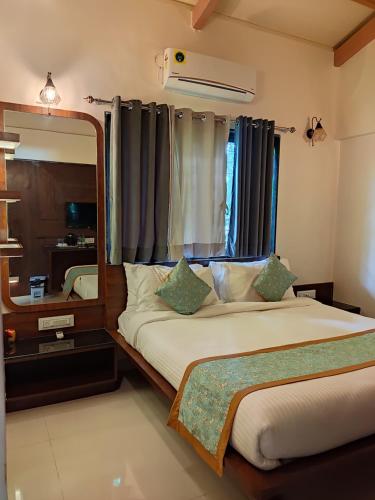 a bedroom with a large mirror and a bed at Cocorico Beach Resort in Dapoli