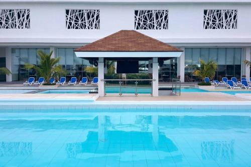 a swimming pool with a gazebo next to a building at Relaxing Stay with Sea View at Arterra in Mactan