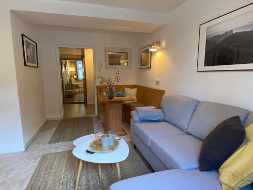 a living room with a couch and a table at FeWo Ostrau, neues Bad, neue Küche, zentral, ruhig, Sandstein-Ferien, Terrasse in Königstein an der Elbe