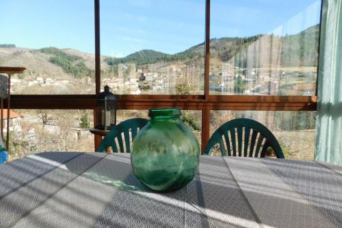 a green glass vase sitting on top of a table at Gîte Le Gravier en haut de Villa proche de la Dolce Via in Arcens