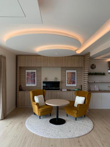 un soggiorno con tavolo e 2 sedie di SXRD Luxus Apartmanok a Szekszárd