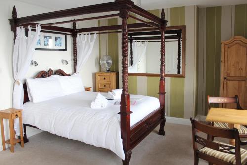 a bedroom with a canopy bed and a table at The Redcliff in Weymouth