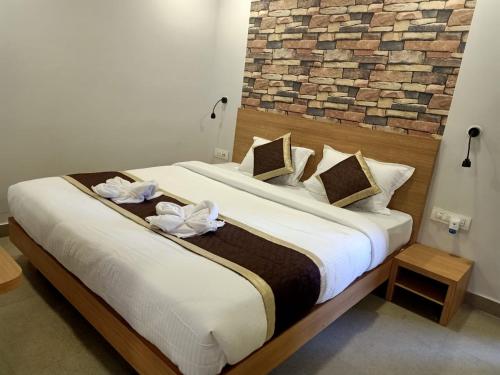 a bedroom with a large bed with white flowers on it at VIPs Hotel Olive in Siliguri