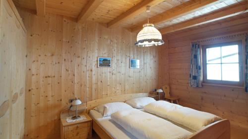 1 dormitorio con 1 cama en una pared de madera en Ferienwohnung Maiernhof Bauernhof Ultental, en San Pancrazio