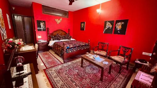 a red bedroom with a bed and a table and chairs at Habba Kadal Kashmiri Heritage Hotel & Hub in Coonoor