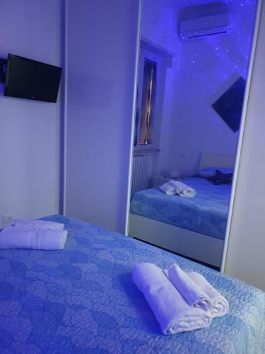 1 dormitorio con 2 toallas en la cama y espejo en SOGNO BLU suite, en Gaeta