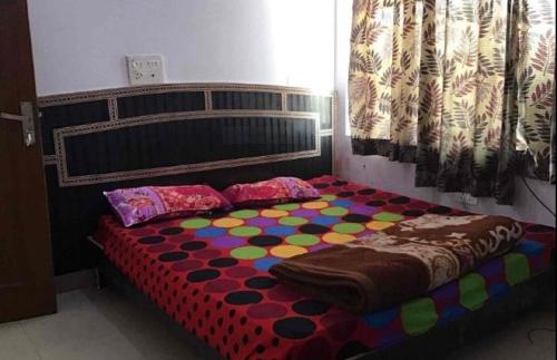 a bed with a colorful comforter in a room at Hotel Moon Star, Panipat in Pānīpat