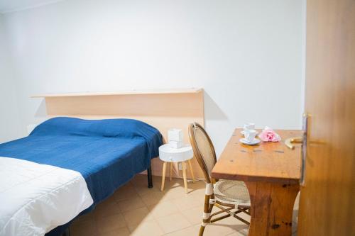 a bedroom with a bed and a desk and a table at Villaggio Smeraldo in Moneglia