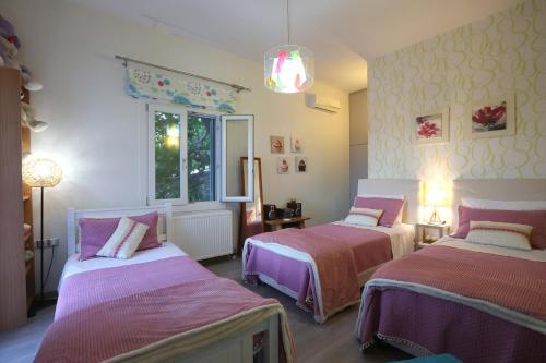 2 camas en una habitación de color púrpura y blanco en Vacation house with stunning view - Vari Syros en Vari