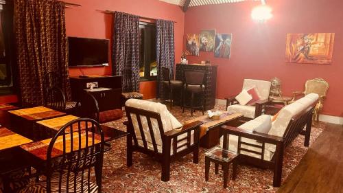 a living room filled with furniture and a tv at Habba Kadal Kashmiri Heritage Hotel & Hub in Coonoor