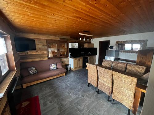 un salon avec un canapé, une table et des chaises dans l'établissement APPARTEMENT COSY AUX SAISIES n1, aux Saisies