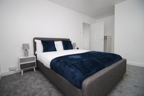 um quarto com uma cama grande e um cobertor azul em Wern farm cottage em Pontypool