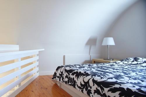 a bedroom with a black and white bed and a lamp at Meltemi Village Hotel in Perissa