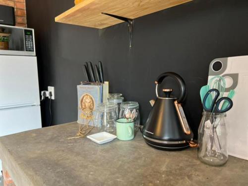 a counter with a tea kettle and other items on it at Krulkop in Kimberley