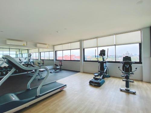 un gimnasio con cintas de correr y elípticas en una habitación con ventanas en Urbanite Hotel en Vientián