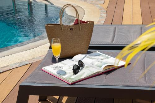 una mesa con un libro y un vaso de zumo de naranja en Urbanite Hotel en Vientián