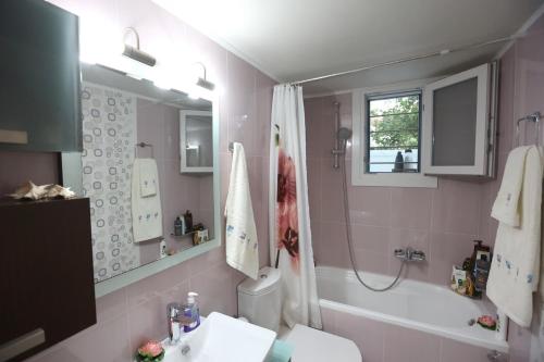 y baño con bañera, lavabo y aseo. en Vacation house with stunning view - Vari Syros en Vari