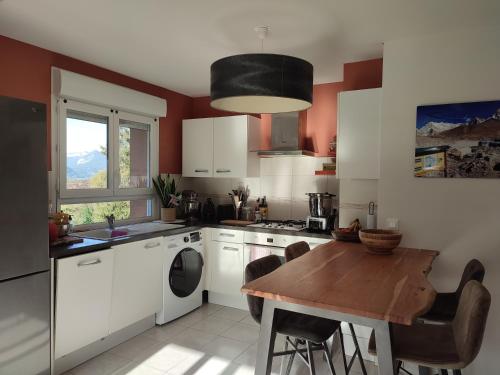 una cucina con un tavolo di legno e una sala da pranzo di Appartement plein centre village, vue montagnes, proximité immédiate lac a Doussard