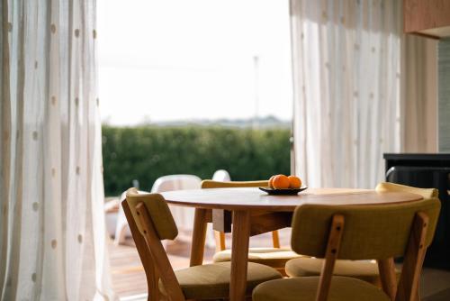 una mesa y sillas con un tazón de naranjas. en Sublime Nooks, en Havelock North