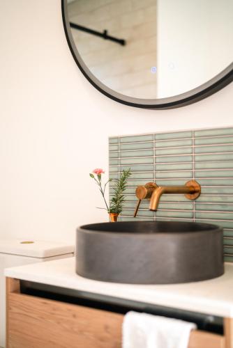 a sink in a kitchen with a clock on the wall at Sublime Nooks in Havelock North