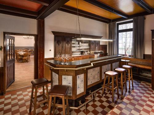 Everswinkel的住宿－Gasthof Strietholt，一个带桌子的房间里,酒吧里摆放着凳子