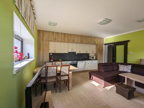 eine Küche und ein Wohnzimmer mit einem Sofa und einem Tisch in der Unterkunft Apartmány KLÍNOVEC - Apartment KEILBERG in Loučná pod Klínovcem