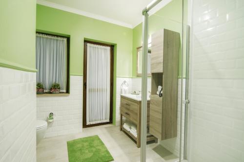 a bathroom with a shower and a toilet and a sink at Rodina Suites Hotel in Kusadası