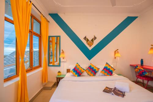 a bedroom with a bed with orange curtains at goSTOPS Bir, Landing Site in Bīr