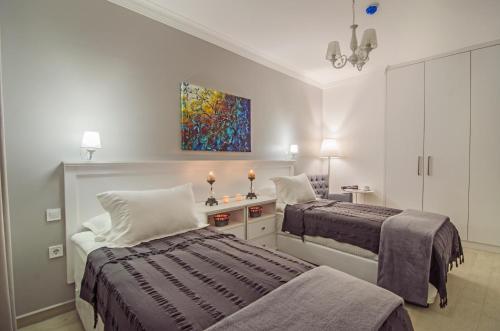 een slaapkamer met 2 bedden en een schilderij aan de muur bij Rodina Suites Hotel in Kuşadası