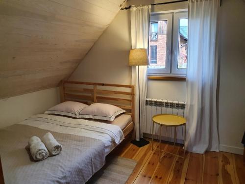 ein Schlafzimmer mit einem Bett mit zwei Kissen und einem Fenster in der Unterkunft Kartkówka in Unichowo