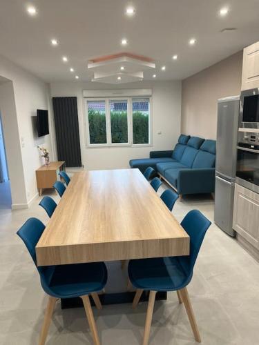 une salle à manger avec une table et des chaises bleues dans l'établissement Maison Rénovée Aux Portes Du Circuit Des 24h, à Mulsanne