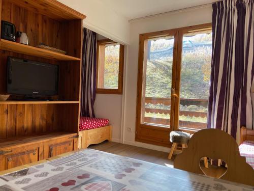 een woonkamer met een televisie en een raam bij Pied des Pistes, 2 pièces, 6pers, Piscine et Sauna in Risoul
