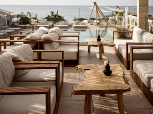 a room with tables and couches and a pool at GARDELLI RESORT in Laganas