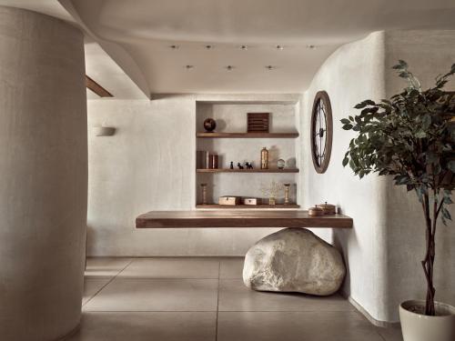 a living room with a bench and a plant at GARDELLI RESORT in Laganas