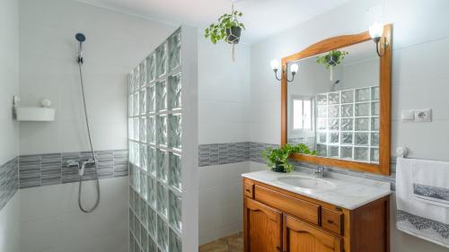 a bathroom with a sink and a shower and a mirror at Casa Pulirio Antequera - La Higuera by Ruralidays in Antequera