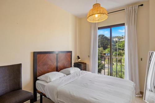 sypialnia z łóżkiem, krzesłem i oknem w obiekcie Costa del Solbeleving pur sang w mieście Castillo de Sabinillas