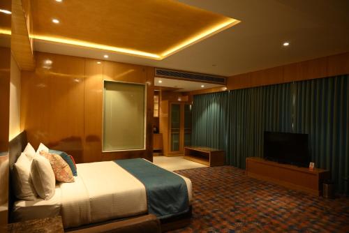 a bedroom with a bed and a flat screen tv at Ramada Plaza by Wyndham Jammu Vijaypur in Jammu