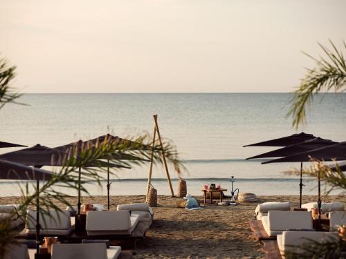 a beach with chairs and umbrellas and the ocean at GARDELLI RESORT in Laganas