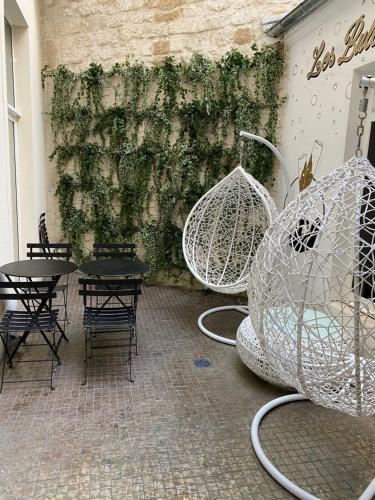 Cette chambre dispose de tables, de chaises et d'un mur orné de plantes. dans l'établissement Hotel Les Bulles De Paris, à Paris