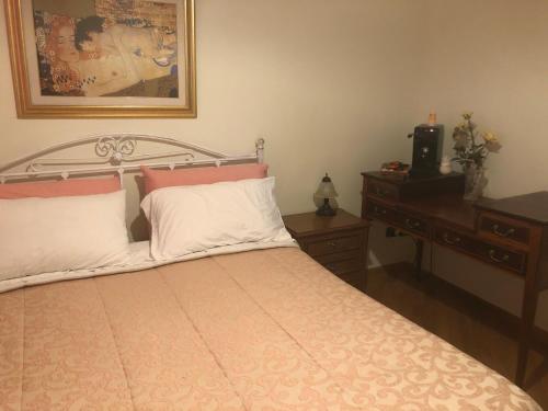 una camera con letto, scrivania e quadro di Villa Radiosa a Gravina in Puglia