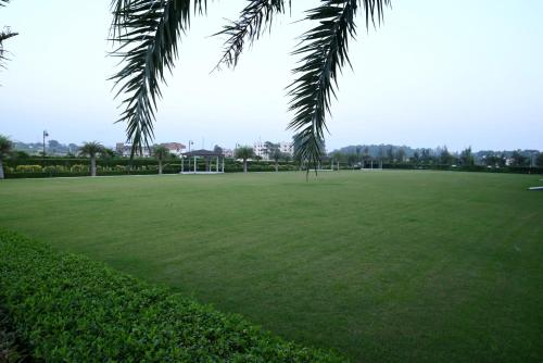 a large green field with a soccer field at Ramada Plaza by Wyndham Jammu Vijaypur in Jammu