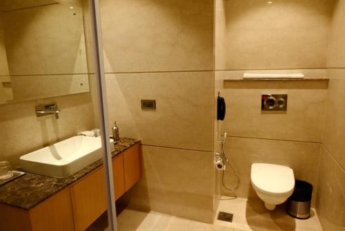 a bathroom with a shower and a toilet and a sink at Ramada Plaza by Wyndham Jammu Vijaypur in Jammu