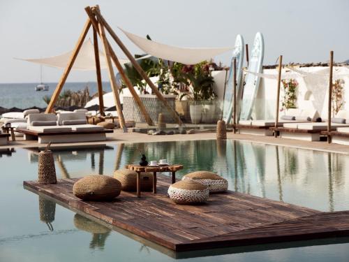 a swimming pool with chairs and a table in the water at GARDELLI RESORT in Laganas